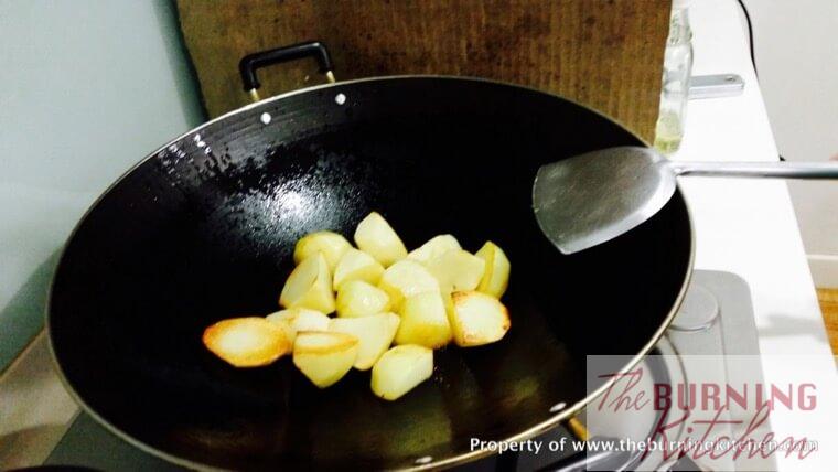 Frying potato pieces in a wok