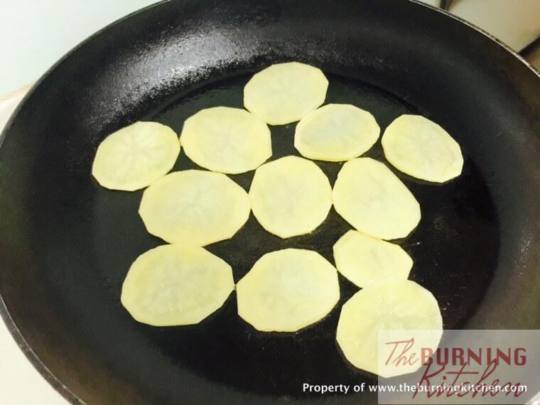 Pan frying potato slices in wok