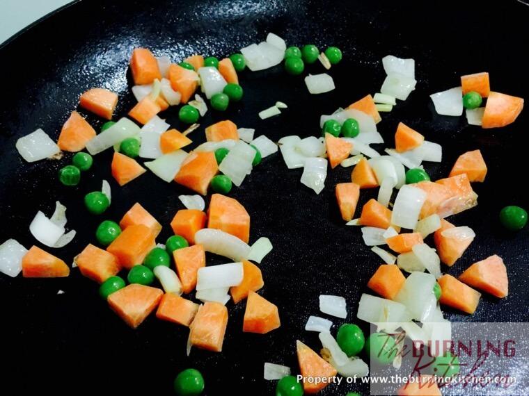 Stir-frying diced carrots, onions and peas in pan