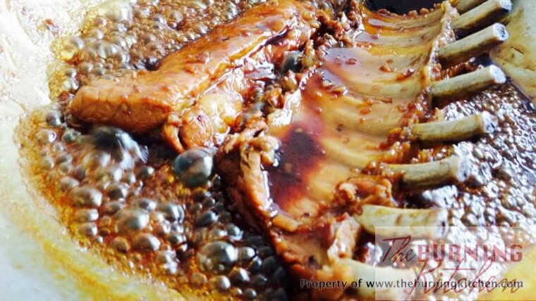 Simmering cooked pork ribs in bubbling, sticky marinade