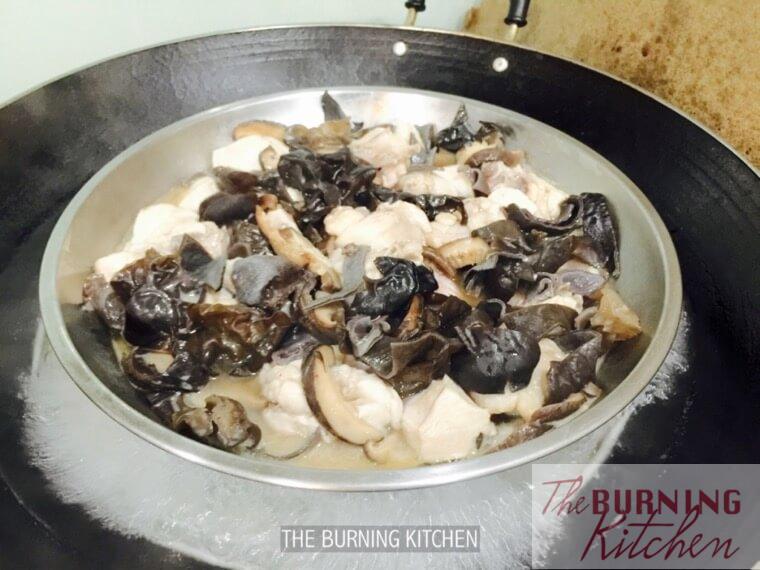 Steaming chicken and black fungus in a wok