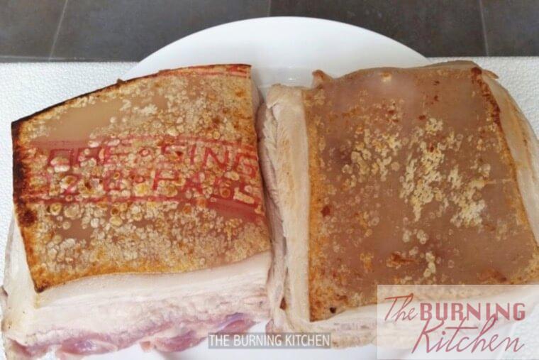 Pork belly with browned skin on a white plate