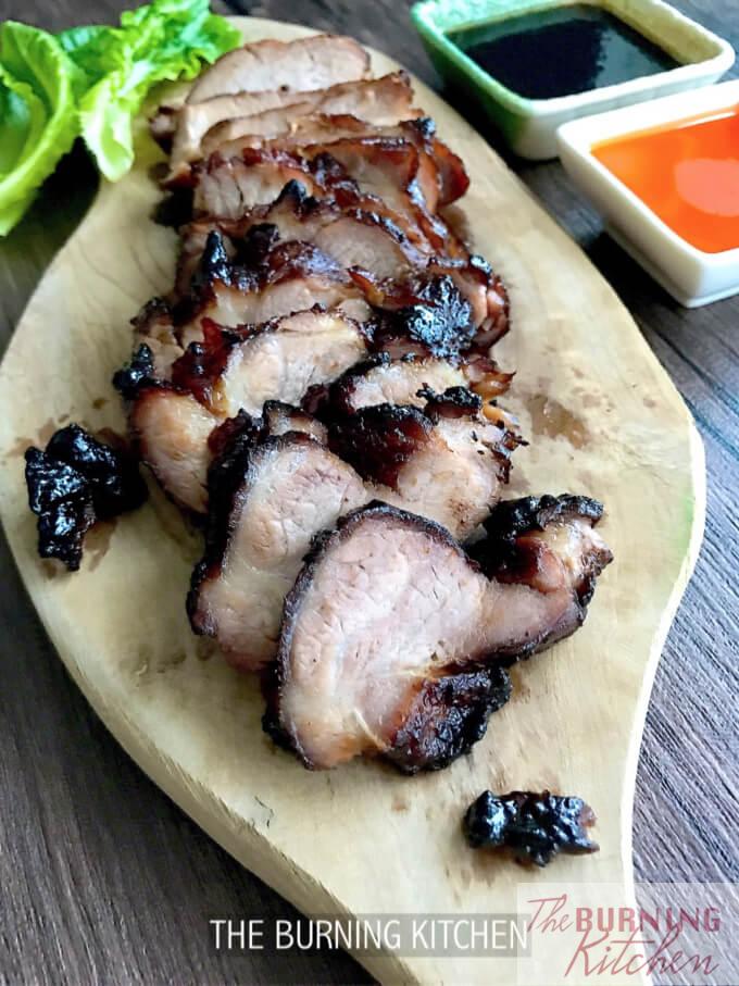 Row of char siew in the backgroun on chopping board