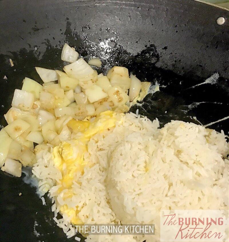 Stir frying rice, eggs and onions in wok
