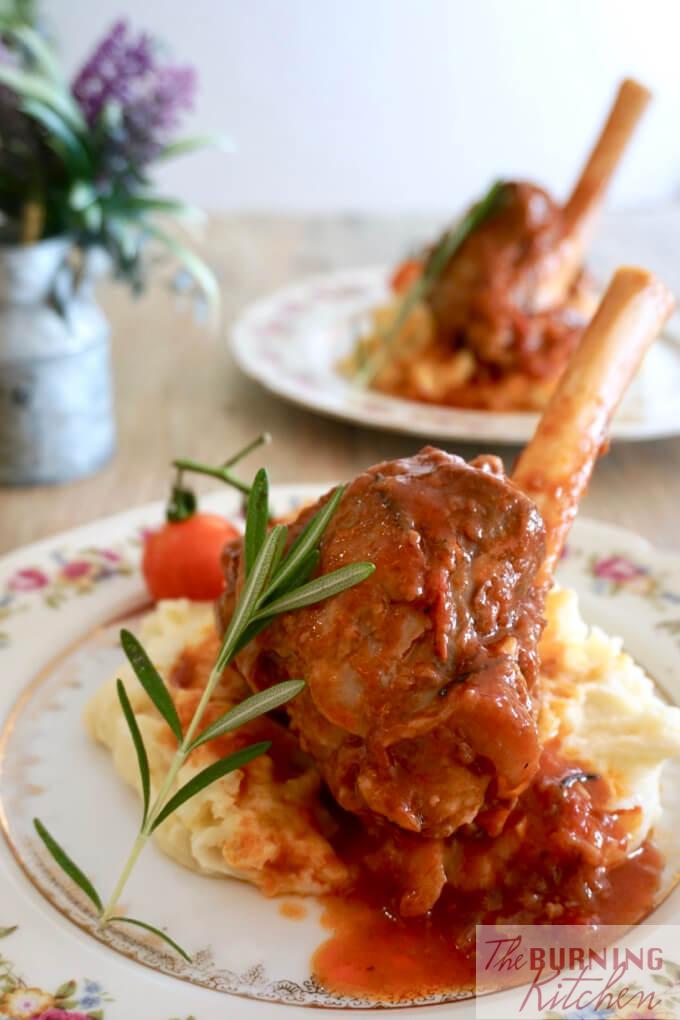 Braised Rosemary Lamb Shank on mashed potatoes with rosemary leaf and roma tomatoes