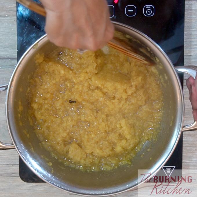 Stirring sugar into pineapple jam mixture in metal pot