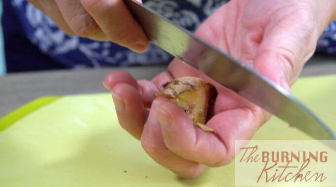 Ginger being peeled using a knife