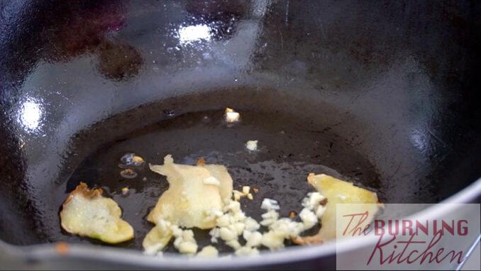 Chopped ginger and garlic stir frying in wok