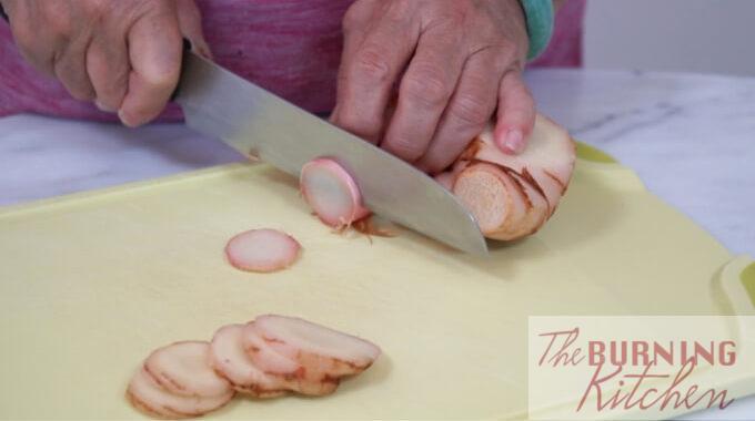 Blue ginger galangal) being sliced on a chopping board