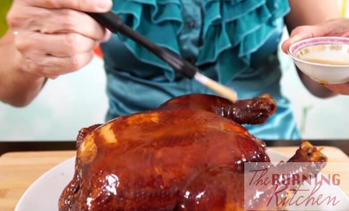 Glazing the soya sauce chicken with maltose syrup