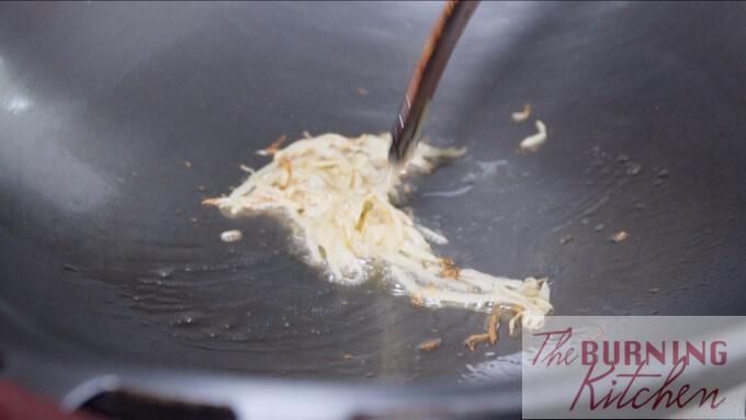 Frying sliced ginger in wok