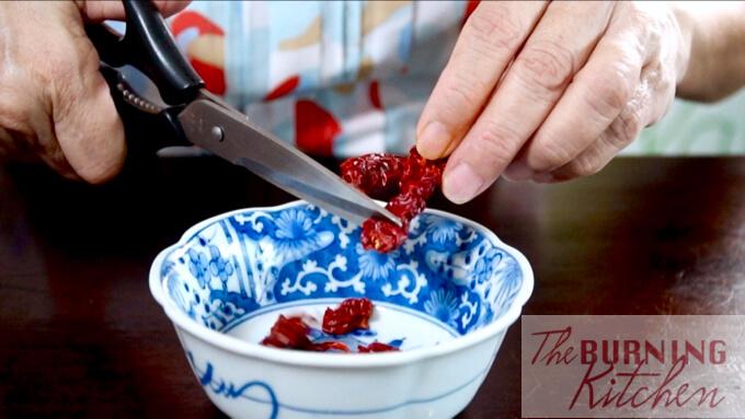 Cutting the dried red chilli into pieces