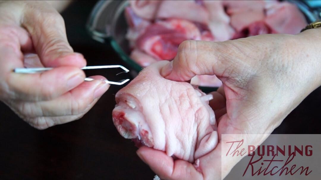 Removing stray hairs from pig trotter
